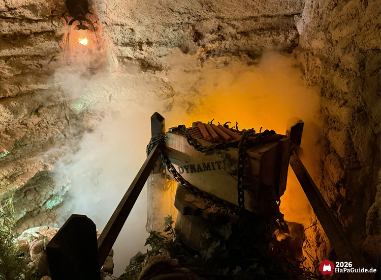 Kiste mit der Aufschrift Dynamit in der Bärenhöhle des Hansa-Parks, umgeben von Nebel und orangefarbenem Licht, erzeugt eine spannende Atmosphäre