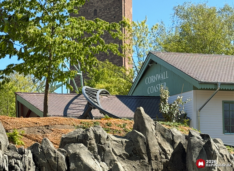 Cornwall Coaster im Freizeitpark Hansa-Park: hellgrünes Bahnhofsgebäude mit Schriftzug, Felsenlandschaft und sichtbarem Achterbahnelement vor blauem Himmel, Foto Mai 2026 von HaPaGuide.de