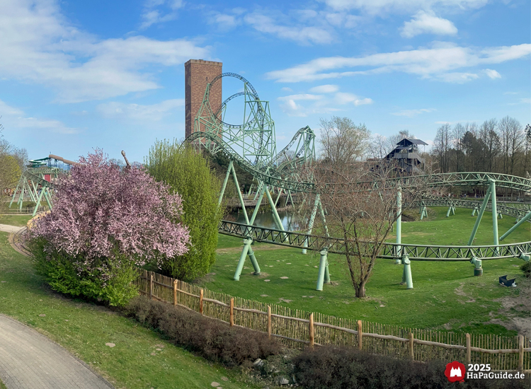 Grünes Herzelement im Hansa-Park vor dem Kärnan-Turm mit blühendem Baum im Vordergrund