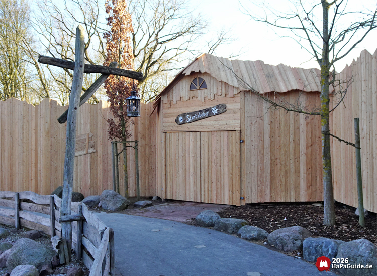 Rustikale Störtebeker-Holzhütte im Hansa-Park mit Zaun, Laterne und kahler Szenerie