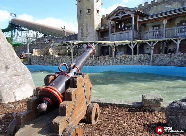 Piratenkulisse im Hansa-Park mit dekorativer Kanone vor Festungsbau und Wasserbereich