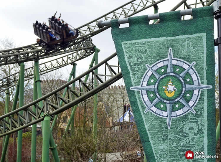 Flucht von Novgorod mit grünem Streckenverlauf im Hansa Park, vorbeifahrender Zug vor Banner mit Kompassmotiv