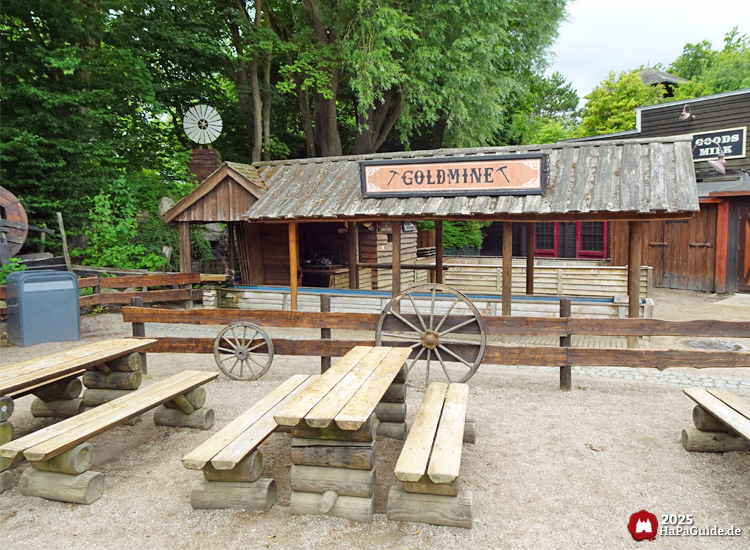 Goldmine - Holztische und -bänke vor der Goldmine von New Lübeck