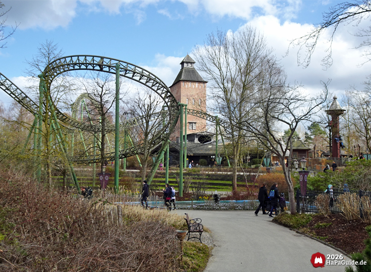 Dunkelgrüne Schienen der Flucht von Novgorod vor russischem Saviour-Backsteinturm mit Spazierlaufenden im Hansa-Park Hansa-Garten