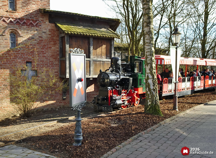 Hansa-Park Express mit roten Waggons fährt am Backsteingebäude des Vladimir-Towers der Flucht von Novgorod vorbei