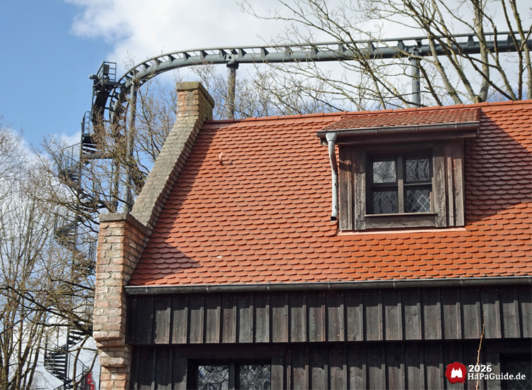 Backsteinhaus mit Holzfassade und vorbeiführender Schiene Nessies im Hansa-Park