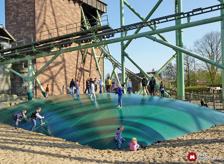 Hüpfberg - Kinder springen auf der grünen PVC-Plane