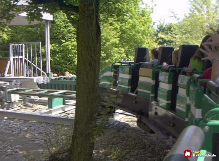 Der grüne Nessie Zug durchfährt die offene Schlusskurve Richtung Station