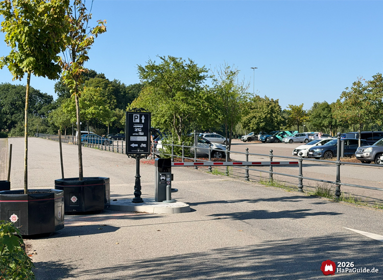 Zufahrt zur Hansa-Park Kurzparkzone mit Schranke, Parkleitsystem-Schild und bepflanzten Baumkübeln
