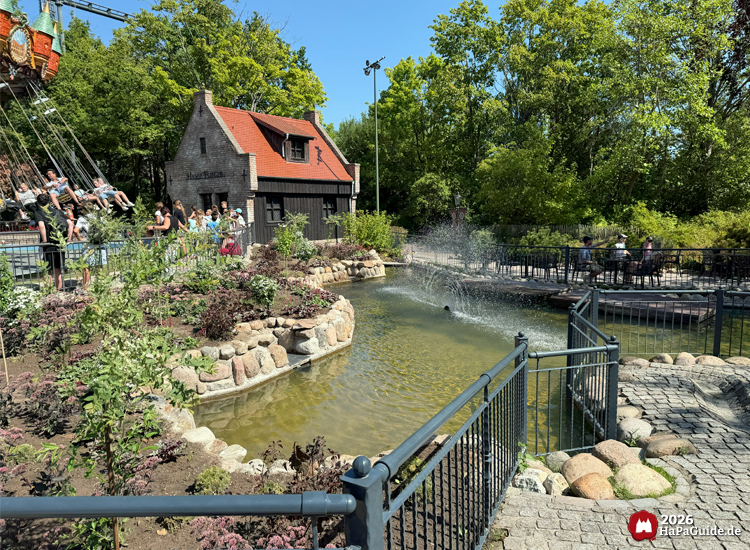 Landschaftlich gestalteter Teich mit Springbrunnen vor dem Hanse-Karussell im Hansa-Park