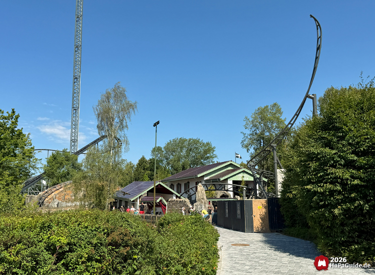 Cornwall Coaster Achterbahnansicht im Hansa-Park mit thematisiertem Gebäude, grüner Bepflanzung und steil aufragendem Schienenende Spike