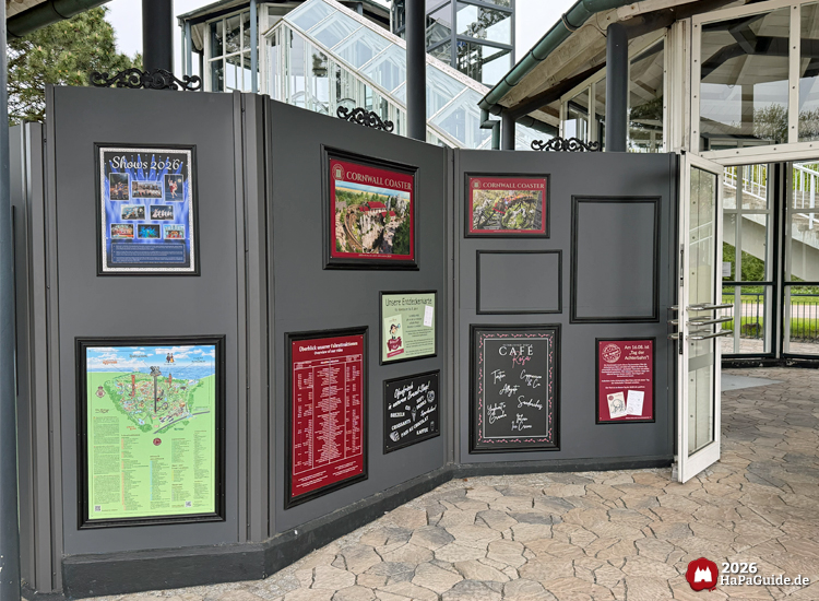 Informationswand auf dem Großparkplatz des Hansa-Parks mit Plakaten zu Shows 2026, Cornwall Coaster, Parkplan, Café-Angeboten und Besuchshinweisen
