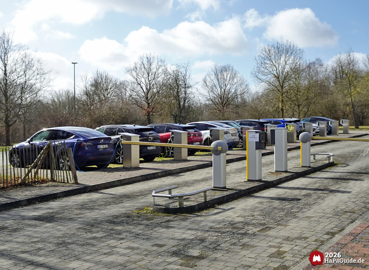 Parkplatz mit mehreren Elektroauto-Ladestationen und parkenden E-Autos am Hansa-Park