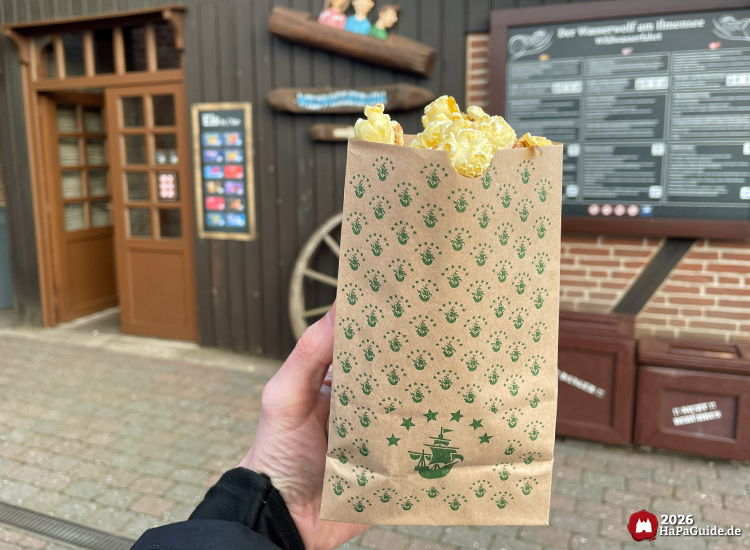 Popcorntüte mit Koggendesign vor dem Eingang zur Wildwasserfahrt - Der Wasserwolf am Ilmensee im Hansa-Park