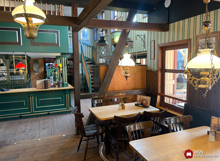 Saloon New Chance - Holztische vor der Bar im Eingangsbereich des Restaurants