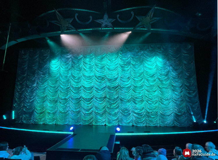 Varieté-Show - Türkis beleuchteter Vorhang im Theatersaal