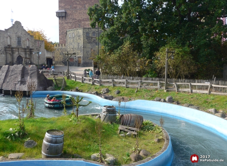 Ein Rundboot treibt durch den Wasserkanal Störtebekers vorbei an alten Fässern