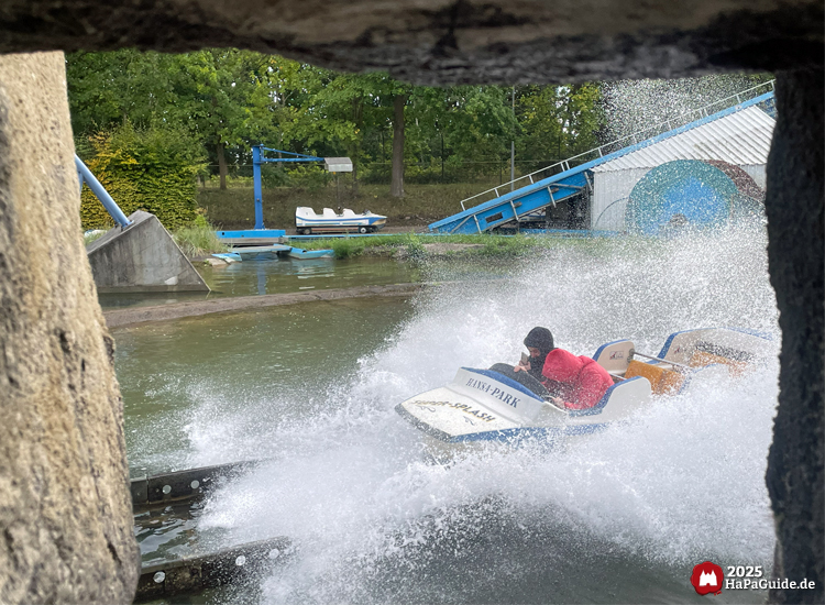 Wasserspaß - Ein Boot von Super Splash taucht hinter Fels spritzend ins Wasser ein